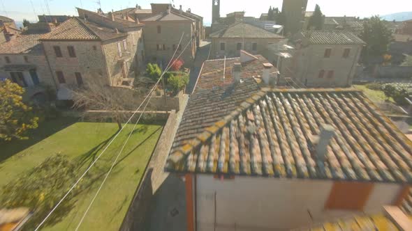 Aerial tilt up over the roofs of the medieval village of Bettolle, Italy. Amazing ancient typical Tu alt