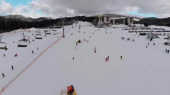 Aerial View on Lot of People Skiing on Ski Slopes Near Ski Lifts on Ski Resort alt