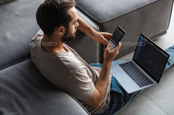 Concentrated young man using laptop computer chatting