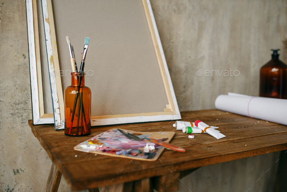 Paints on palette, brush in bottle, canvas, nobody - Stock Photo - Images