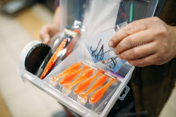 Angler holds box with hooks and baubles - Stock Photo - Images