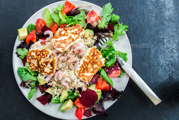 Warm Salad from Brown Rice, Quinoa, Prawns, Halloumi and Veg - Stock Photo - Images