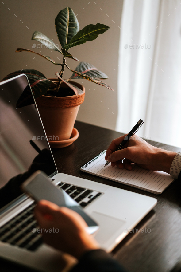 Businessman making notes and using gadgets - Stock Photo - Images
