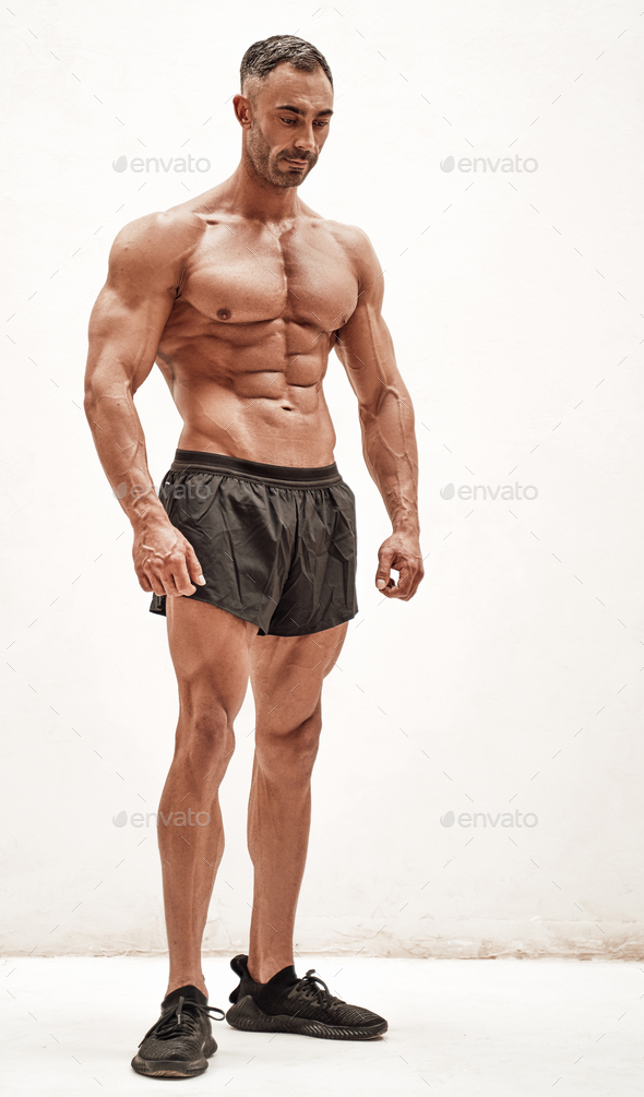 Shirtless sporty caucasian male isolated on a white concrete background looking down - Stock Photo - Images