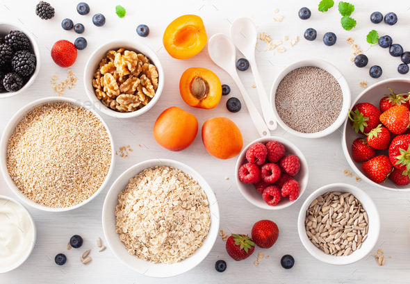 raw cereals, fruits and nuts for breakfast. Oatmeal flakes and steel cut, barley, walnut, chia - Stock Photo - Images