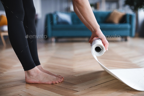 Female folding rubber carpet after yoga session finished sport training. - Stock Photo - Images