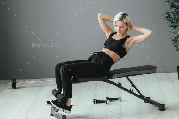 Sport. Woman in sport gym making exercise training. Sporty blonde female with sporty equipment.