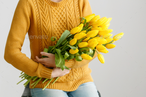Woman with tulips. Young brunette girl with yellow flowers tulip natural portrait lifestyle near