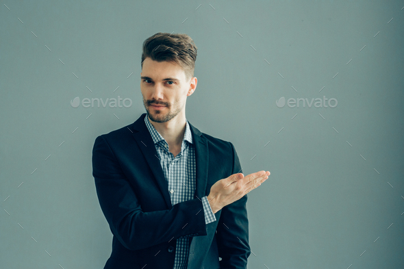 Success man in suit over gray wall. Successful male handsome guy portrait.