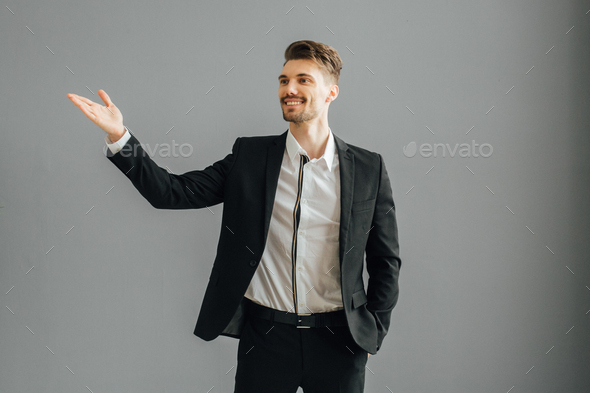 Success man in suit over gray wall. Successful male handsome guy portrait.