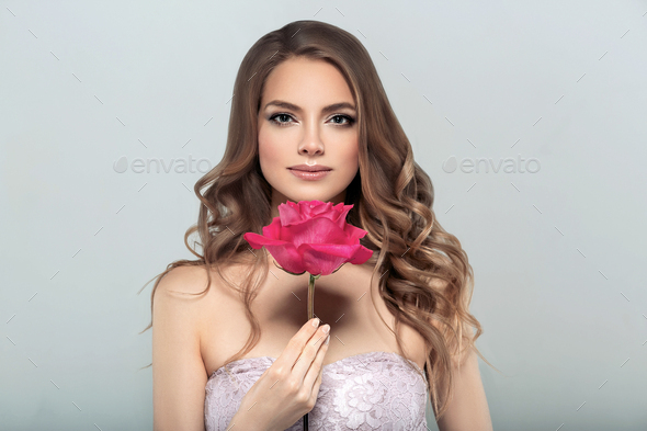 Woman with rose flower. Beauty female portrait with beautiful rose flower and salon hairstyle. - Stock Photo - Images
