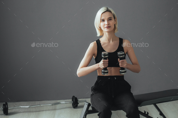 Sport. Woman in sport gym making exercise training. Sporty blonde female with sporty equipment.