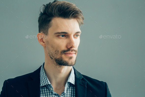 Handsome man in suitover gray wall. Businessman male portrait fashion style guy