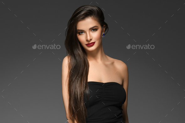 Beautiful woman with long brunette smooth beauty hair over dark backgroun. Female model portrait - Stock Photo - Images