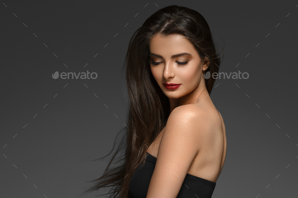 Beautiful woman with long brunette smooth beauty hair over dark backgroun. - Stock Photo - Images