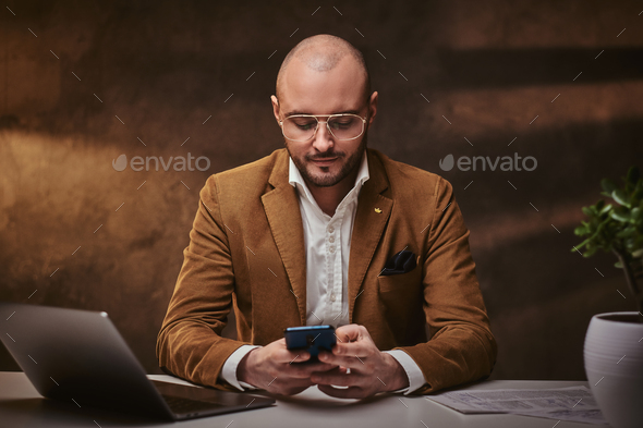 Confident european handsome businessman sitting in the office - Stock Photo - Images