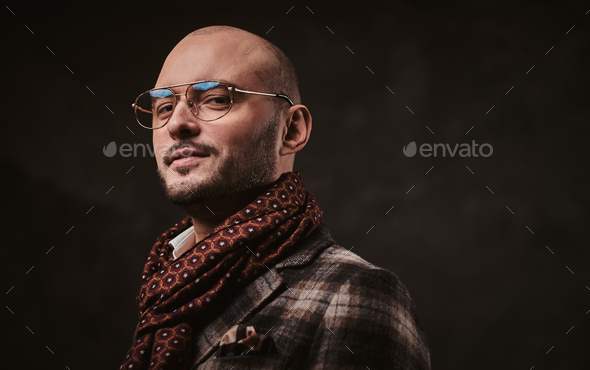 Successful stylish businessman posing in a studio wearing checkered jacket, glasses and scarf - Stock Photo - Images