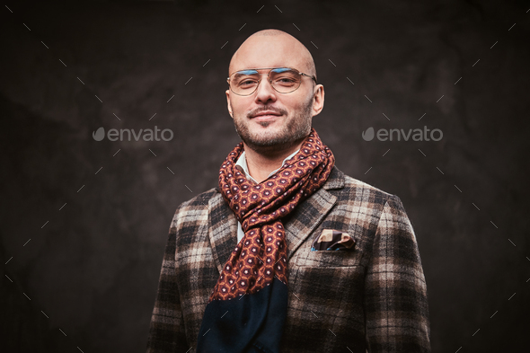 Succesful stylish businessman posing in a studio wearing checkered jacket, glasses and scarf - Stock Photo - Images