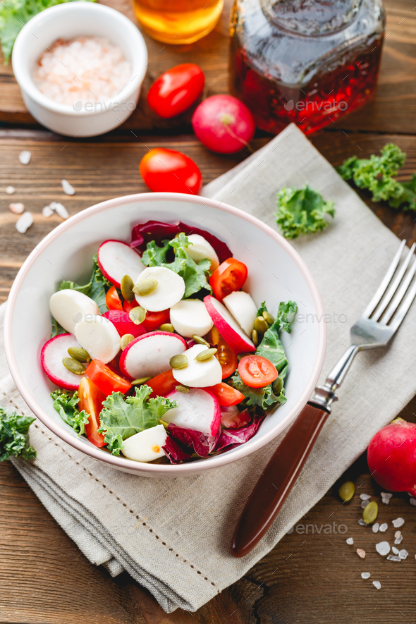 Salad with cherry tomatoes, radsh and mozzarella, lettuce mix - Stock Photo - Images