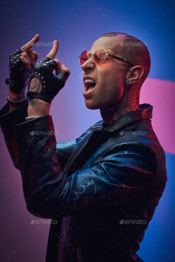 Fashionable tattooed male model posing in a studio - Stock Photo - Images
