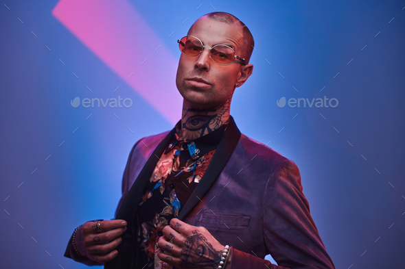 Elegant tattooed male model posing in a studio - Stock Photo - Images