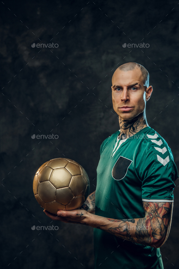 Handsome soccer player holding a golden soccer ball - Stock Photo - Images