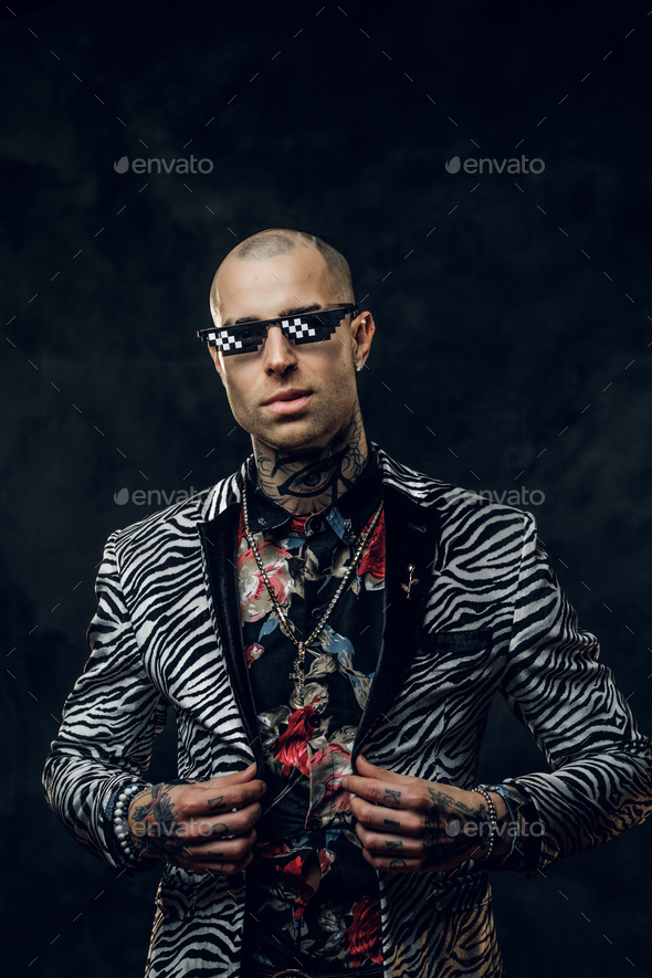 Fashionable tattooed male model posing in a studio - Stock Photo - Images