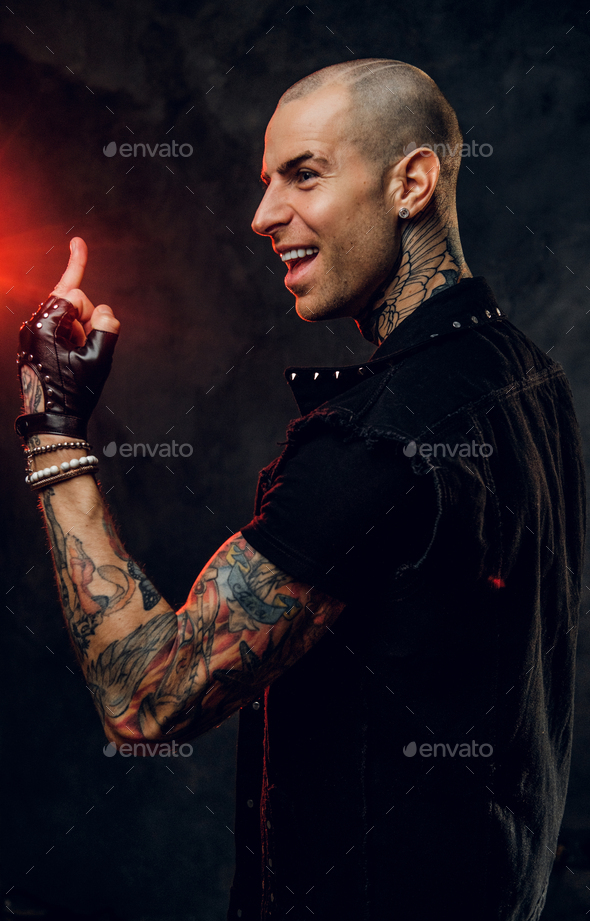 Fashionable tattooed male model posing in a studio - Stock Photo - Images
