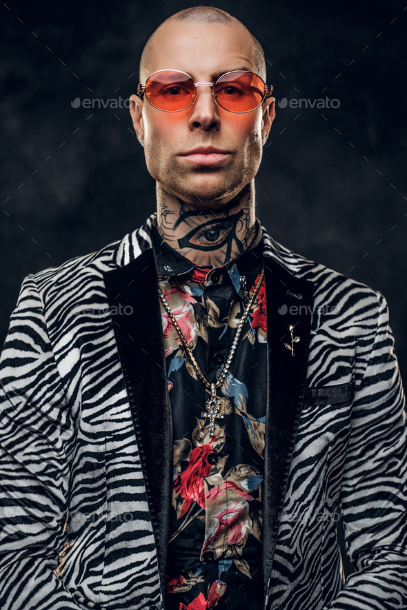 Calm tattooed, bald fashionable male model posing in a studio for the photoshoot, portrait close up - Stock Photo - Images