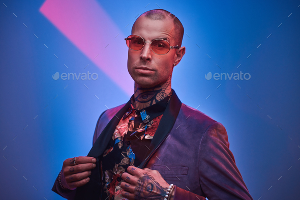 Fashionable tattooed male model posing in a studio - Stock Photo - Images