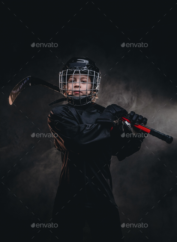 Young hockey player posing in uniform for a photoshoot in a studio