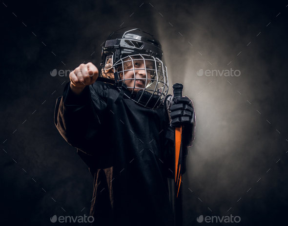 Young hockey player posing in uniform for a photoshoot in a studio - Stock Photo - Images