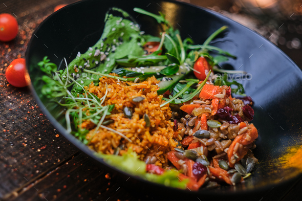 Cooked vegetarian bowl of plov on a wooden table - Stock Photo - Images