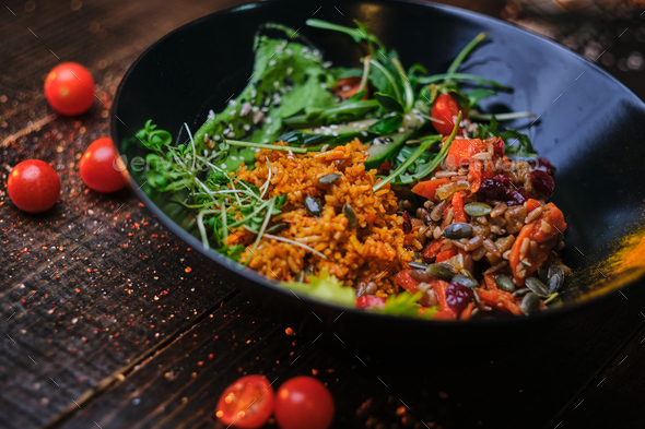 Cooked vegetarian bowl of plov on a wooden table - Stock Photo - Images