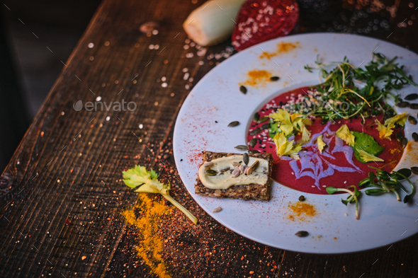 Healthy vegetarian beetroot sauce which includes green sprouts and herbs served on a porcelain dish - Stock Photo - Images