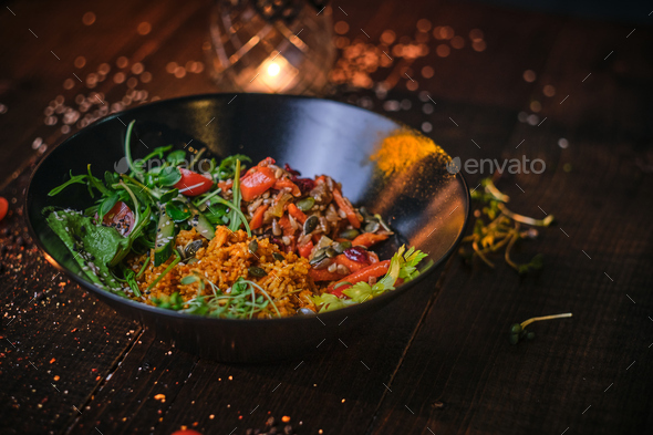 Cooked vegetarian bowl of plov on a wooden table - Stock Photo - Images