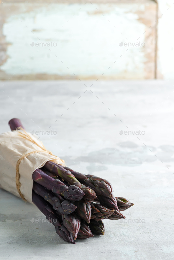 Home grown fresh natural organic purple asparagus bunch against stone background - Stock Photo - Images