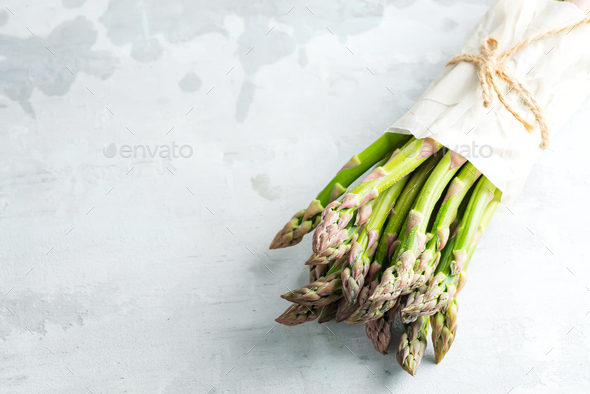 Vertical standing home grown fresh natural organic green asparagus bunch against stone background - Stock Photo - Images