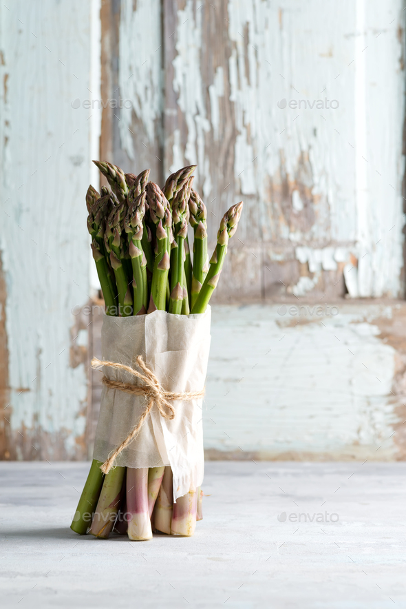 Freshly picked natural organic green asparagus bunch on light stone background - Stock Photo - Images