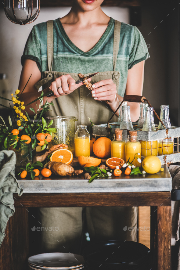 Young woman making fruit immune boosting drink to resist virus - Stock Photo - Images