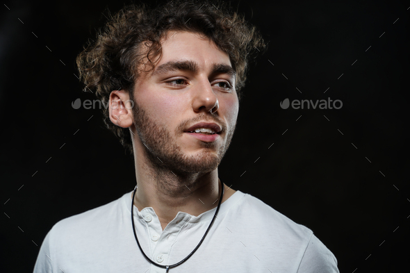Handsome and casual-looking man posing for the photoshoot on the dark background - Stock Photo - Images