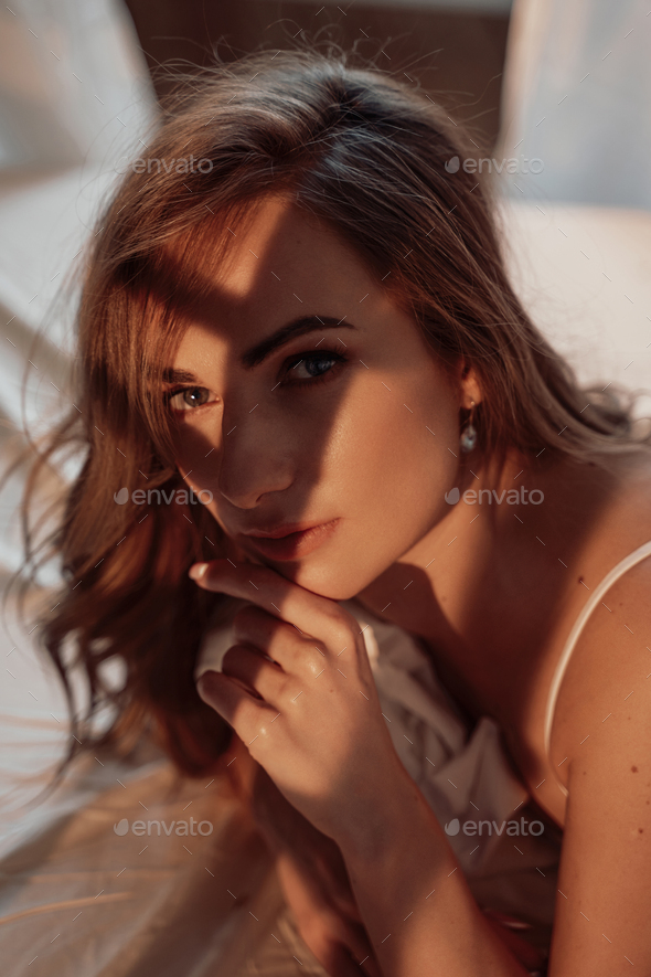 Portrait of an attractive and hot woman with fit body laying on a bed wearing lace lingerie - Stock Photo - Images