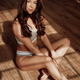 Young female model in sporty underwear sitting on the floor in a room  filled with sunlight Stock Photo by fxquadro