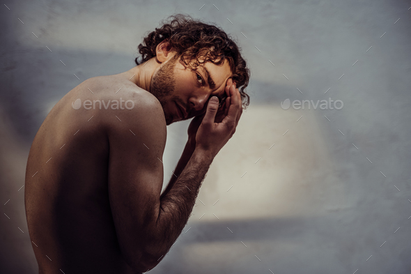 Young caucasian male model is naked and isolated on the grey background - Stock Photo - Images