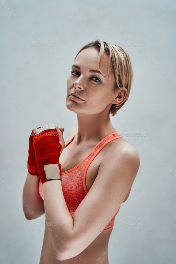 Sportive adult female model with blonde hair and orange fitness bra posing  in a bright room Stock Photo by fxquadro