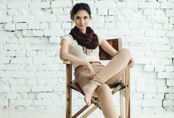 Beautiful Woman Natural Casual Portrait on chair near brick wall.