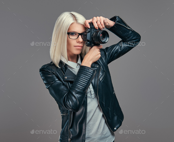 Smart fashionable blogger female in modern clothes and glasses in a studio