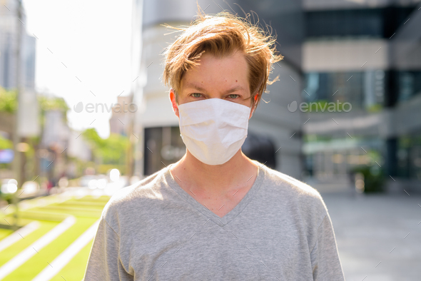 Face of young man wearing mask for protection from corona virus outbreak outdoors