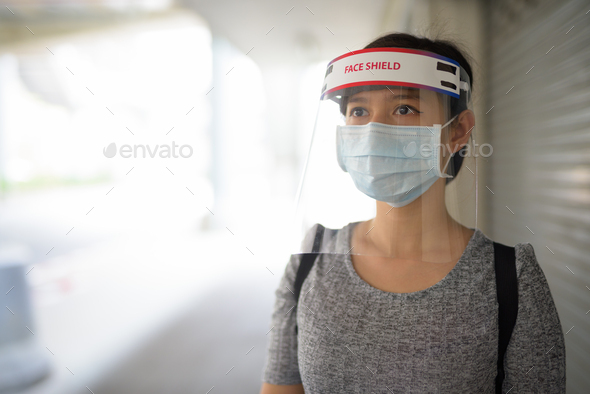Young Asian woman thinking with mask and face shield for protection from corona virus outbreak in