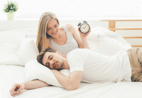 Young woman and man portrait in bedroom on bed relaxing sleep